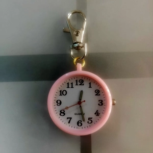 Detailed macro view of pink quartz pocket watch with silver keychain clip for students