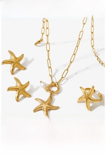 Detailed view of gold starfish jewelry set with necklace, earrings, and open ring on white background