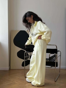 Women's pale yellow two-piece tracksuit with half-zip sweatshirt and wide-leg trousers