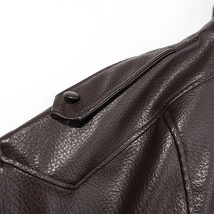 Gros plan de l'épaulette avec bouton sur une veste en cuir marron foncé