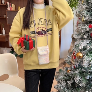 Detailed plush crossbody phone bag in macaron knit texture shown with festive cozy outfit