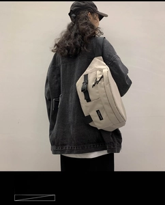 Dettaglio della borsa a tracolla beige in nylon con cinturino a fibbia nera e stile utility