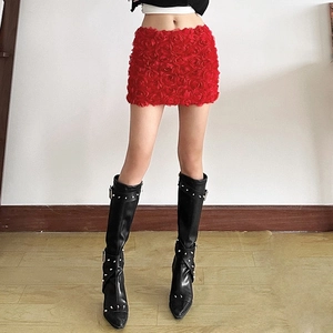 Detailed close-up of a red mini skirt with dense 3D rose floral decorations and texture