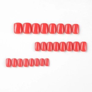 Glossy red short press-on nails set with 24 pieces in various sizes on white background