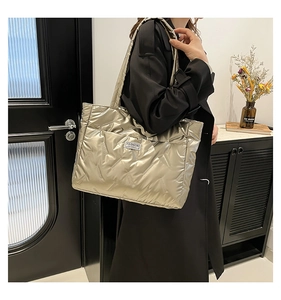 Silver-grey quilted tote bag with diamond pattern shown on a shoulder in a modern room