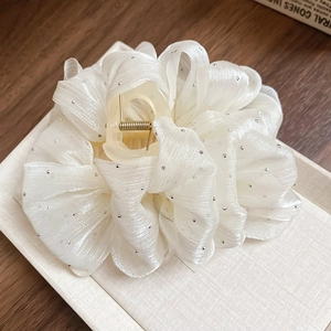 Detailed view of large off-white mesh claw clip with sparkling silver rhinestones