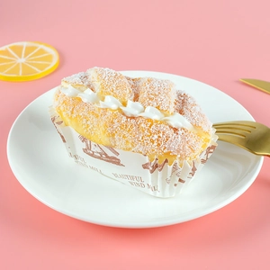 Macro shot of faux cream-filled bread on a white plate with elegant gold cutlery