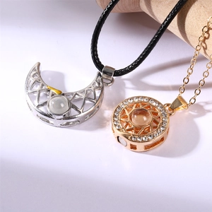 Close-up of magnetic sun and moon necklaces with 100 languages love projection stones