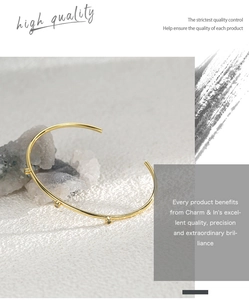 Detail of adjustable brass gold-plated open bangle featuring three inlaid zircons