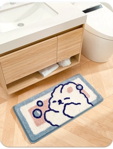 Detail of plush cartoon rabbit bathroom mat showing soft texture and blue border finish