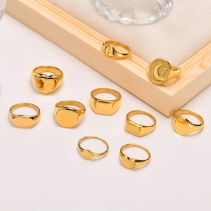 Detailed close-up of gold stainless steel signet rings with geometric and floral engravings