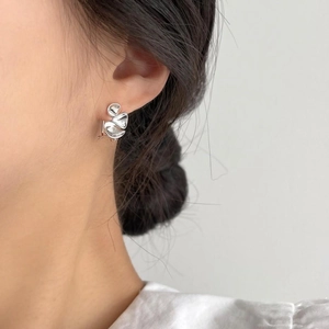 Irregular silver textured S925 heart earrings worn by a model in a minimalist style