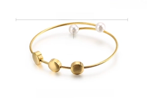 Detail of golden stainless steel wire bracelet with shell pearls and weight specifications