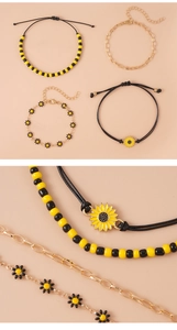 Dettaglio dei ciondoli a girasole e margherita gialla su set di bracciali con perline