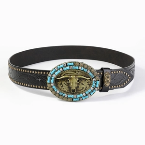 Vue rapprochée de ceinture cuir western vintage avec boucle crâne taureau turquoise.