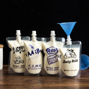 Self-standing spout pouches for milk and juice with blue funnel on a wooden surface