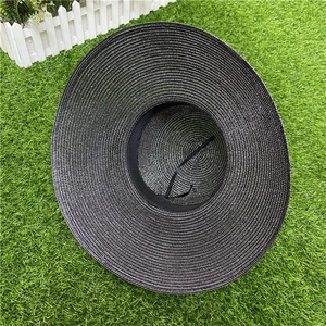 Detail of black wide brim straw hat with spiral weaving texture and adjustable strap