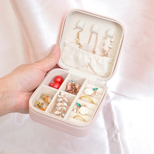 Pink portable travel jewelry organizer box with slots for rings and necklaces