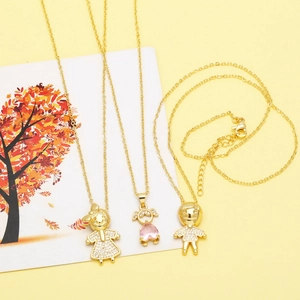 Detailed close-up of golden family cartoon pendants with pink heart and pavé crystals