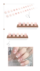Detail of pink gradient press-on nails with hand-painted cherry blossom and shimmer finish