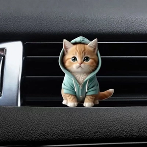Close-up of orange tabby cat air vent clip wearing a teal hoodie car interior decoration