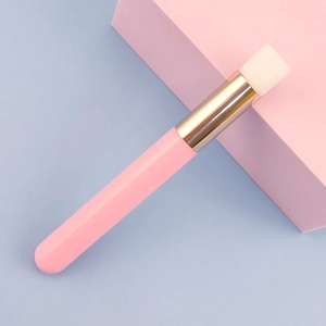 Detail of pink pore cleansing brush with gold ferrule and soft white bristles