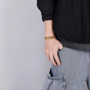 Close-up of a chunky gold Cuban link bracelet for men made of polished stainless steel