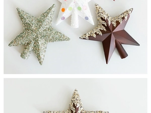 Detail of Christmas tree star toppers in glitter green, white dots, and matte brown finishes