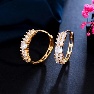 Macro de boucles d'oreilles dorées avec deux rangées de cristaux de zircone brillants