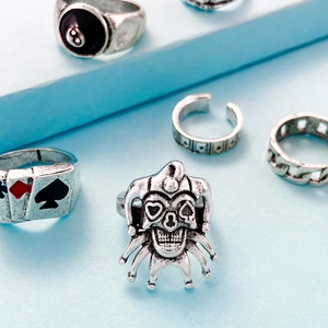 Detail of vintage silver rings featuring skull, poker card, and 8-ball billiard patterns