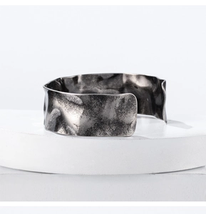 Detail of vintage silver open cuff bracelet with hammered wavy texture and industrial finish