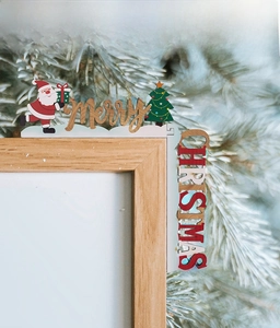 Detail of wooden Merry Christmas corner ornament with Santa and tree on door frame
