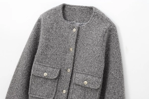 Détail de la veste en tweed gris avec col rond et boutons dorés en métal doré