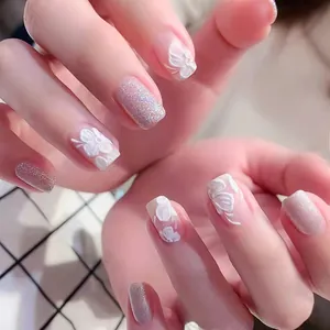 Close-up of 5D relief nail stickers featuring white flowers and pink gradient glitter