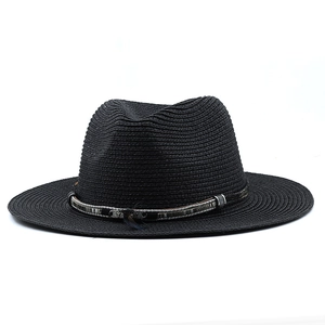 Detail of black straw sun hat showing ethnic style ribbon and silver feather charm
