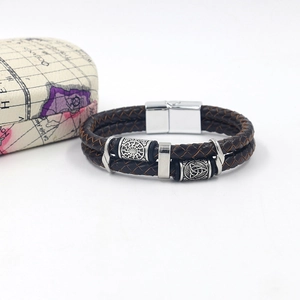 Detail of Viking style braided leather bracelet for men with silver metal beads