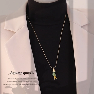 Détail du pendentif carpe koi vintage sur chaîne dorée porté avec un style automnal
