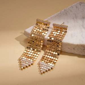 Détail macro de boucles d'oreilles pompons plaquées or 18 carats avec oxydes de zirconium