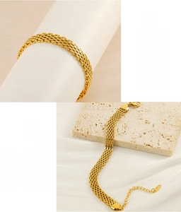 Detail of woven stainless steel mesh bracelet with lobster clasp and golden finish
