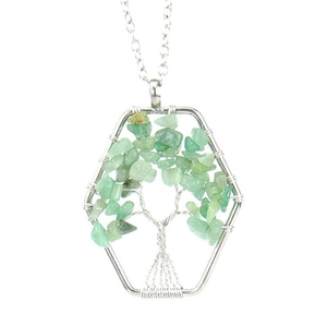 Macro detail of wire-wrapped tree of life pendant with green natural crystals on hexagonal frame