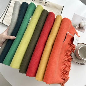 Solid color cashmere-feel scarf with tassels folded for a soft winter shawl display