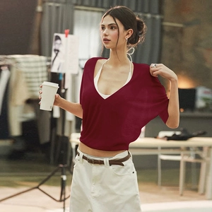 Detail of deep red sheer knit cover-up top with deep V-neckline and waist tie design