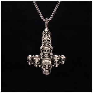 Macro detail of silver punk skull pendant with stacked skull design on long box chain