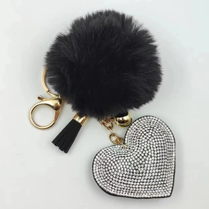 Detail view of black faux fur pompom keychain with rhinestone heart and gold clasp