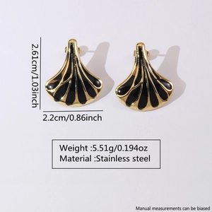 Detail view of fan-shaped stainless steel earrings with gold and black enamel finish