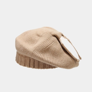 Close-up of oatmeal knitted beret showing soft wool texture and ribbed edge detail