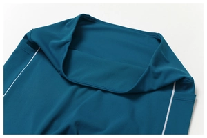 Detalle de pantalones de yoga de talle alto azul cerceta con costuras de precisión y ribete