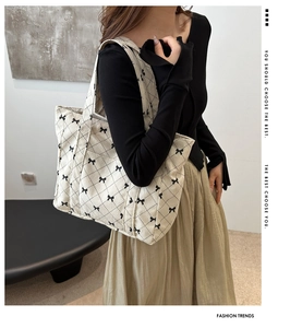 Detailed view of beige corduroy tote bag with black diamond quilting and bow patterns