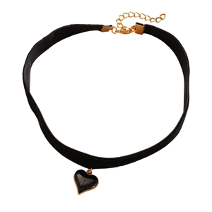 Dettaglio di choker in velluto nero con ciondolo a cuore dorato e catena di estensione