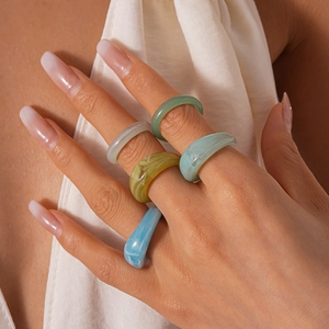 Minimalist geometric acrylic resin rings with marble texture worn by a model